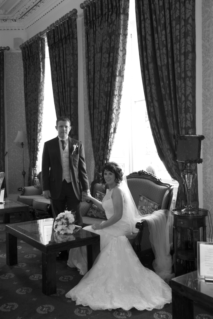 The bride and groom pose for a wedding photograph in the drawing room at at Finnstown Country House Hotel, Lucan