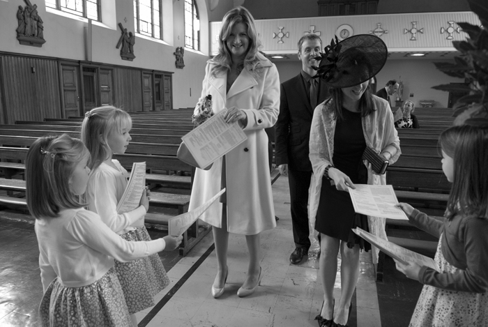 The flowers girls hand mass booklets to guests arriving for a wedding at Mount Argus Church in Dublin