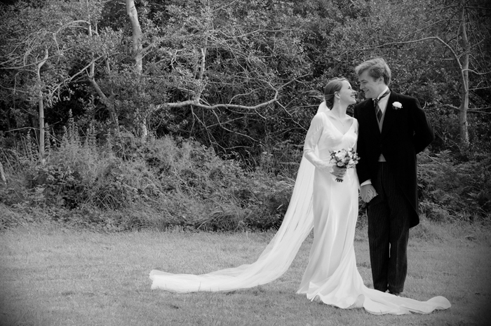 The bride and groom pose for a wedding portrait in the grounds of  a country church in Sneem on The Ring of Kerry
