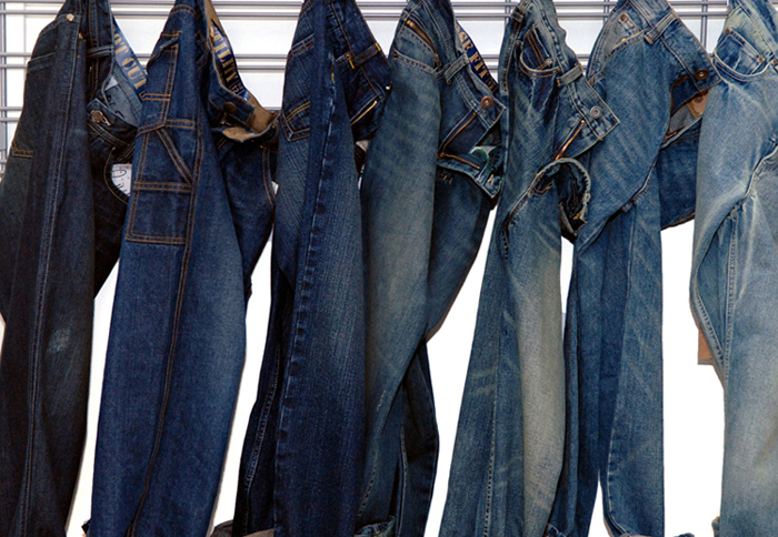 A product photograph of jeans haning on a rail for a denim fashion line