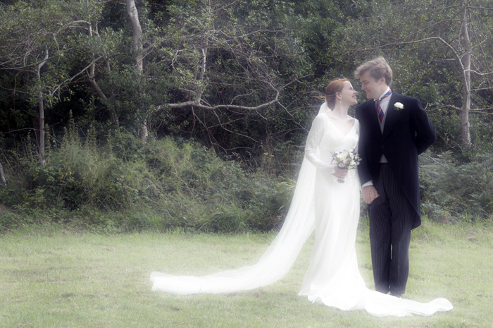 The bride and grrom pose for a wedding portrait in the grounds of a country church in Kerry. Ireland